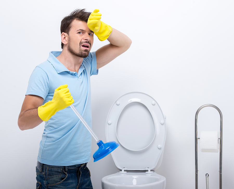 Plumber working on overflowing toilet