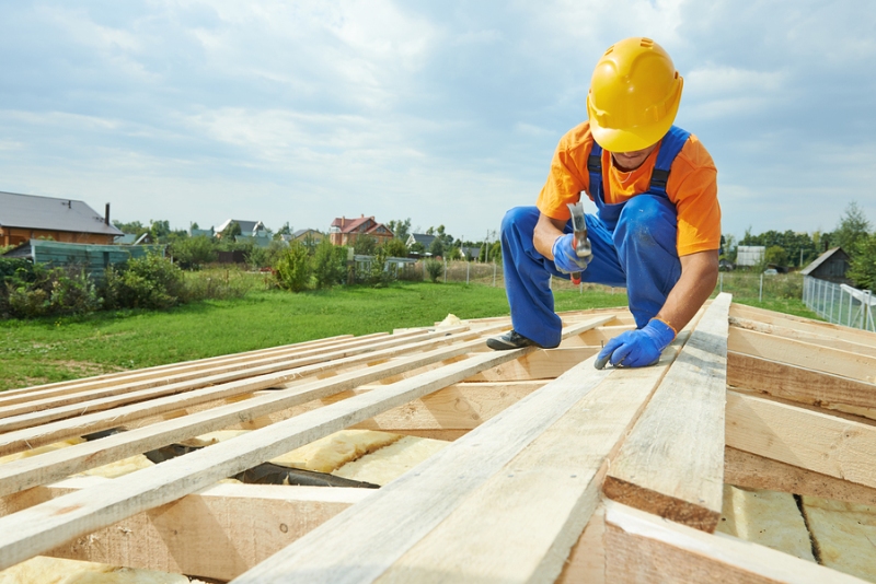 A professional construction worker working on a home's roof