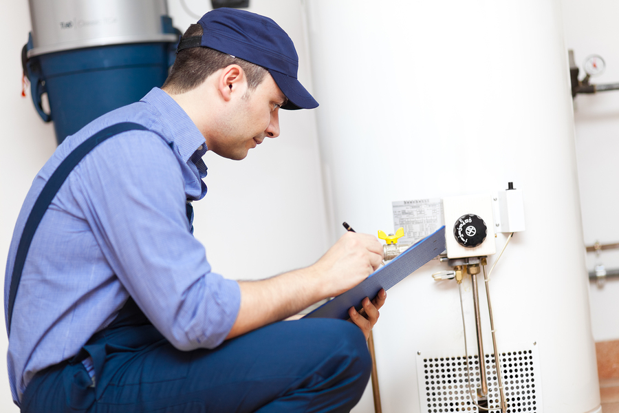 A plumber repairing a leaking water heater