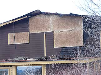 Damaged home requiring board up services.