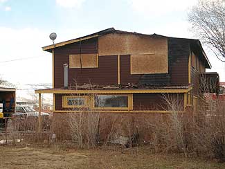 Damaged home requiring board up services.